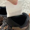 Person applying a white patch to the inside of a brown shoe