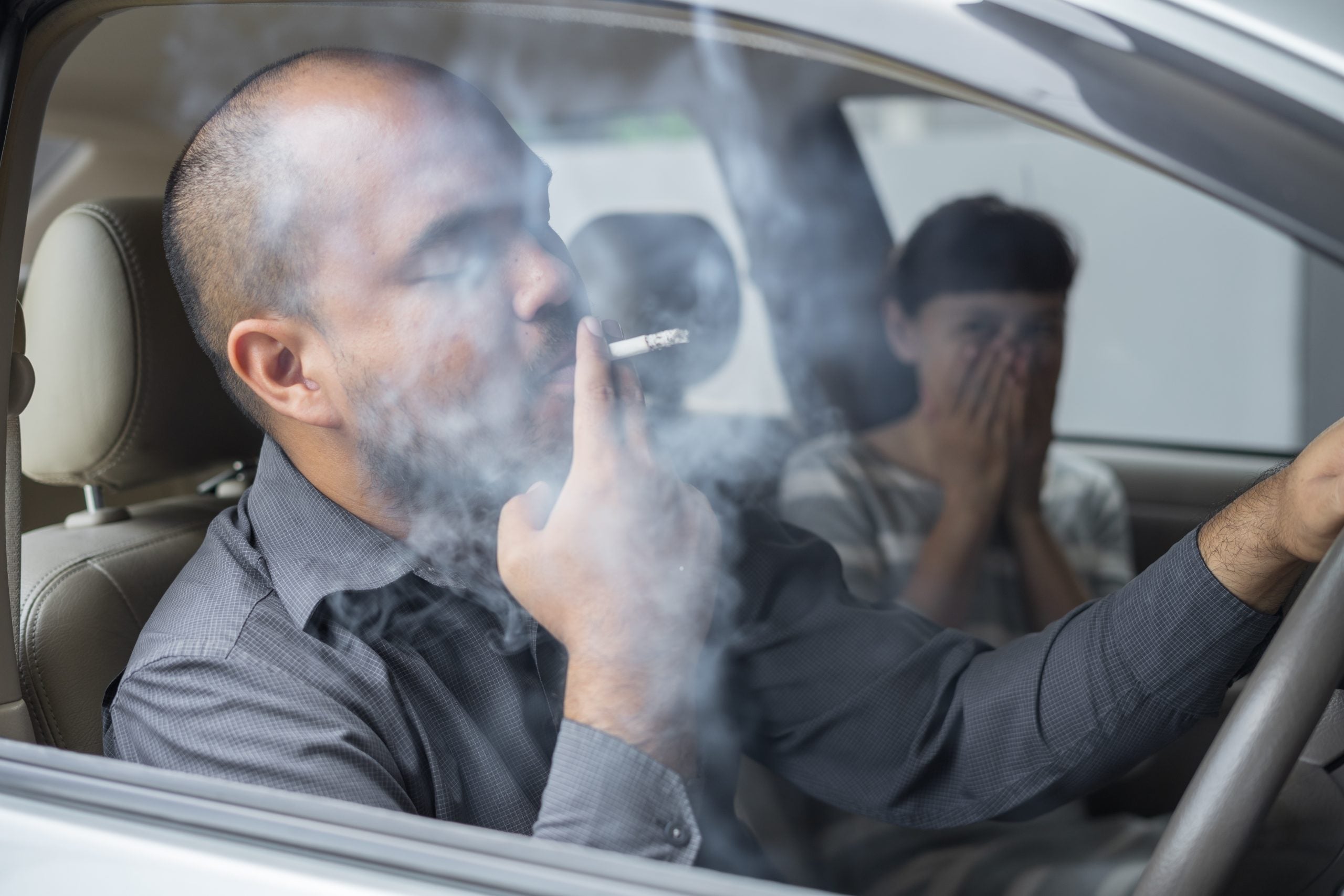 Passenger reacting to smoke inside a car